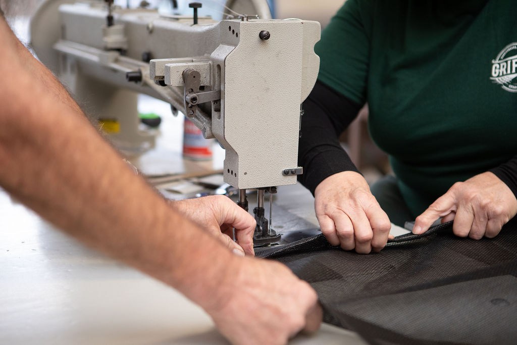 closeup of workers sewing shade cloth